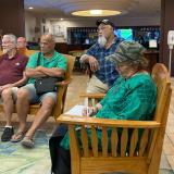Congresswoman Amata taking notes as Veterans discuss their experiences with VA and travel services