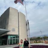 Members of Congress Amata and Neal Dunn in Papua New Guinea in front of the US Flag