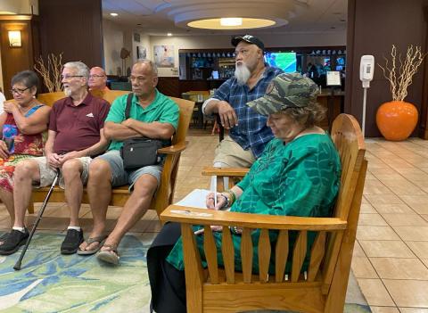 Congresswoman Amata taking notes as Veterans discuss their experiences with VA and travel services