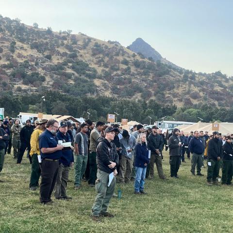 Firefighters assembling with the camp in the background
