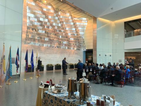 The original Star Spangled Banner from the War of 1812 is displayed in a darkened room just behind this backdrop