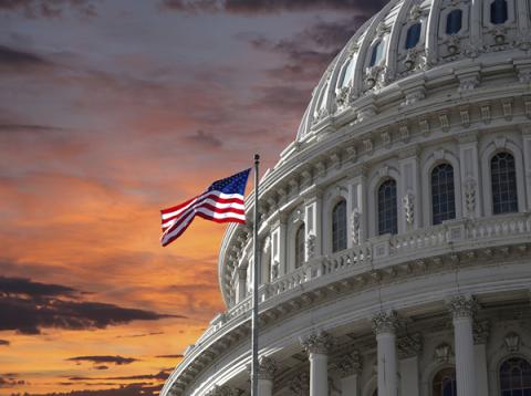 Capitol Dome and U.S. Flag against dramatic sky